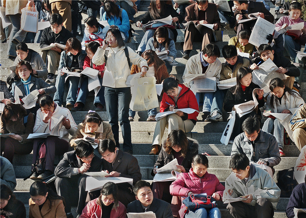 《等待面试的大学生》2003年11月摄于南京    大学生们在全省高校毕业生供需洽谈会上找单位准备面试，近千家用人单位提供的五万多个岗位，成为近20万毕业生关注的焦点。   田鸣 摄.jpg