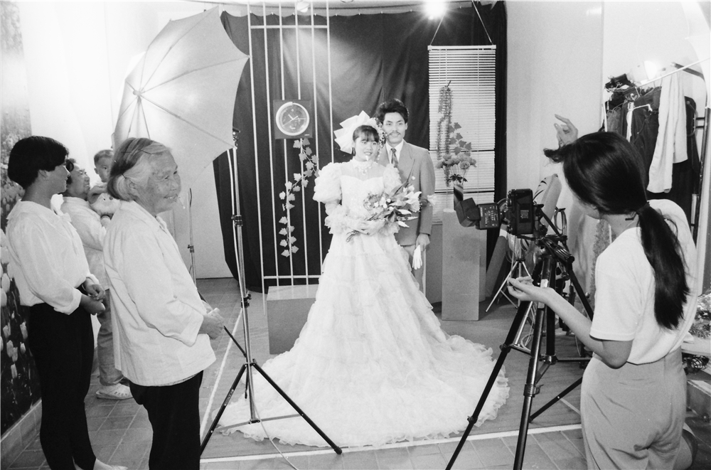 《乡间影楼》80年代青年人结婚是拍一套婚纱照片，也在农村时尚起来。图为无锡一家小影楼拍摄婚纱照时喜气洋洋的情景。    王广林 摄.jpg